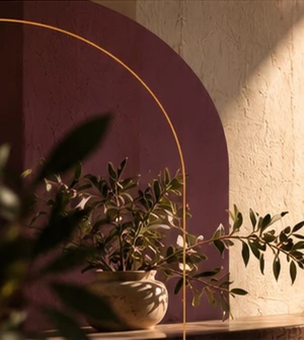 A plum-painted arch on a sunlit plaster wall, with an olive branch in a stone bowl.